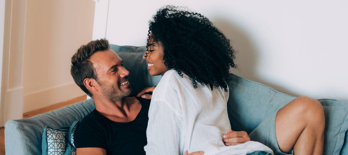 Loving young caucasian couple sitting together at home spending time and  happy to be together. Happy