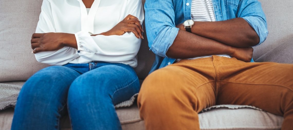 Black couple sitting with arms crossed