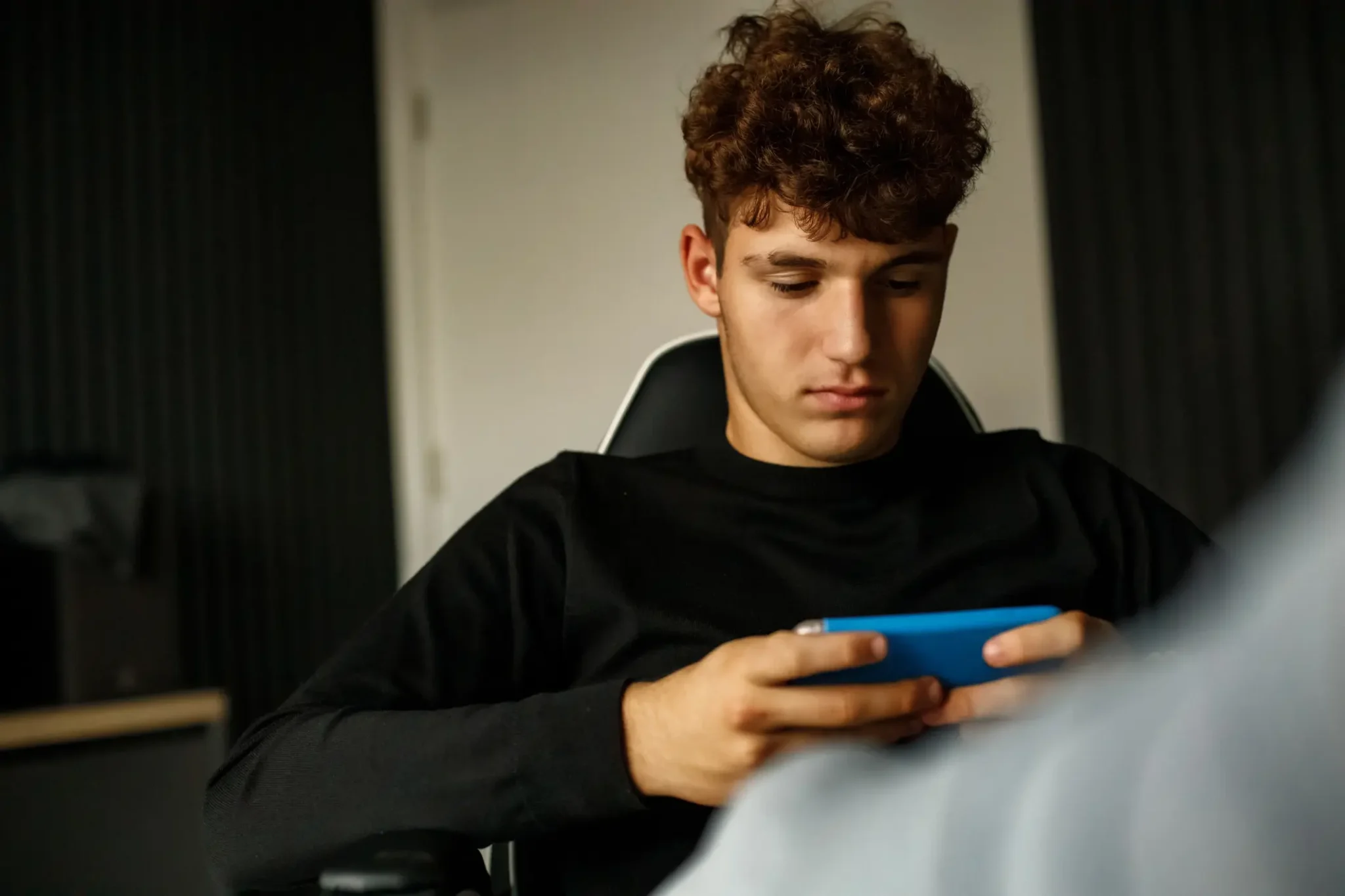 Adolescent male on his phone.