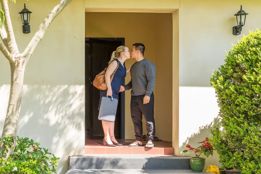 A couple saying goodbye, making the most of a small moment in their daily routine.