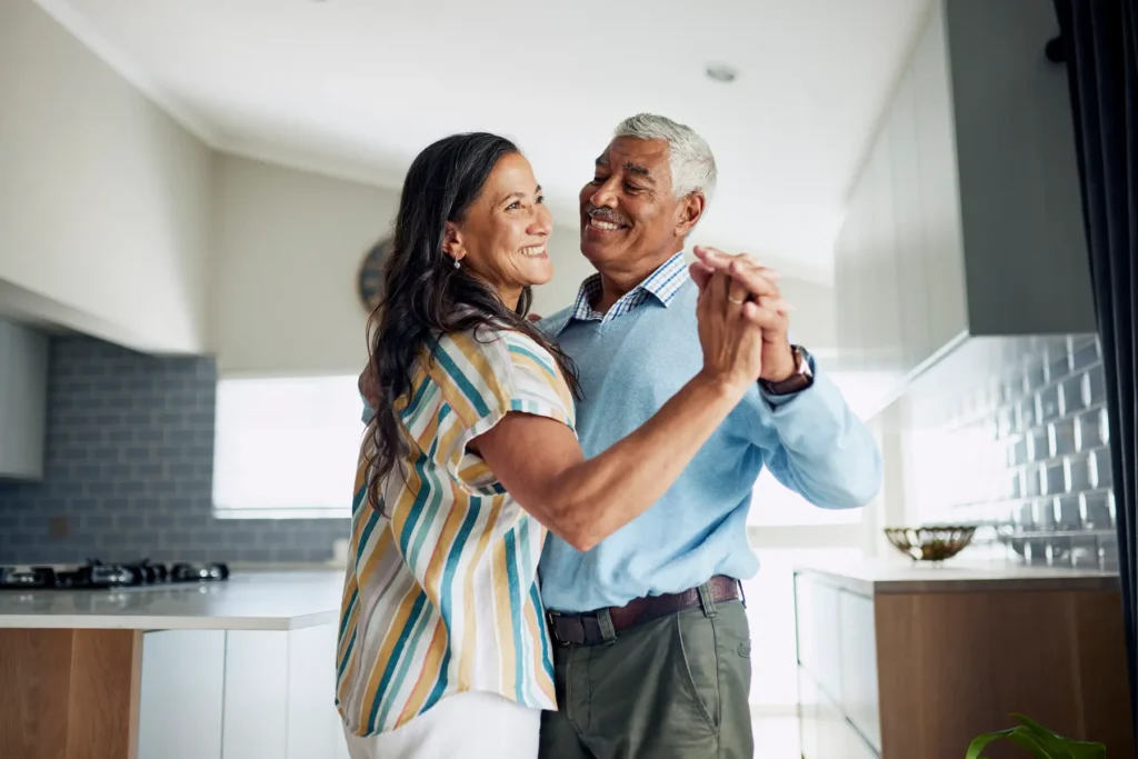 Older couple happily dancing together in their kitchen
